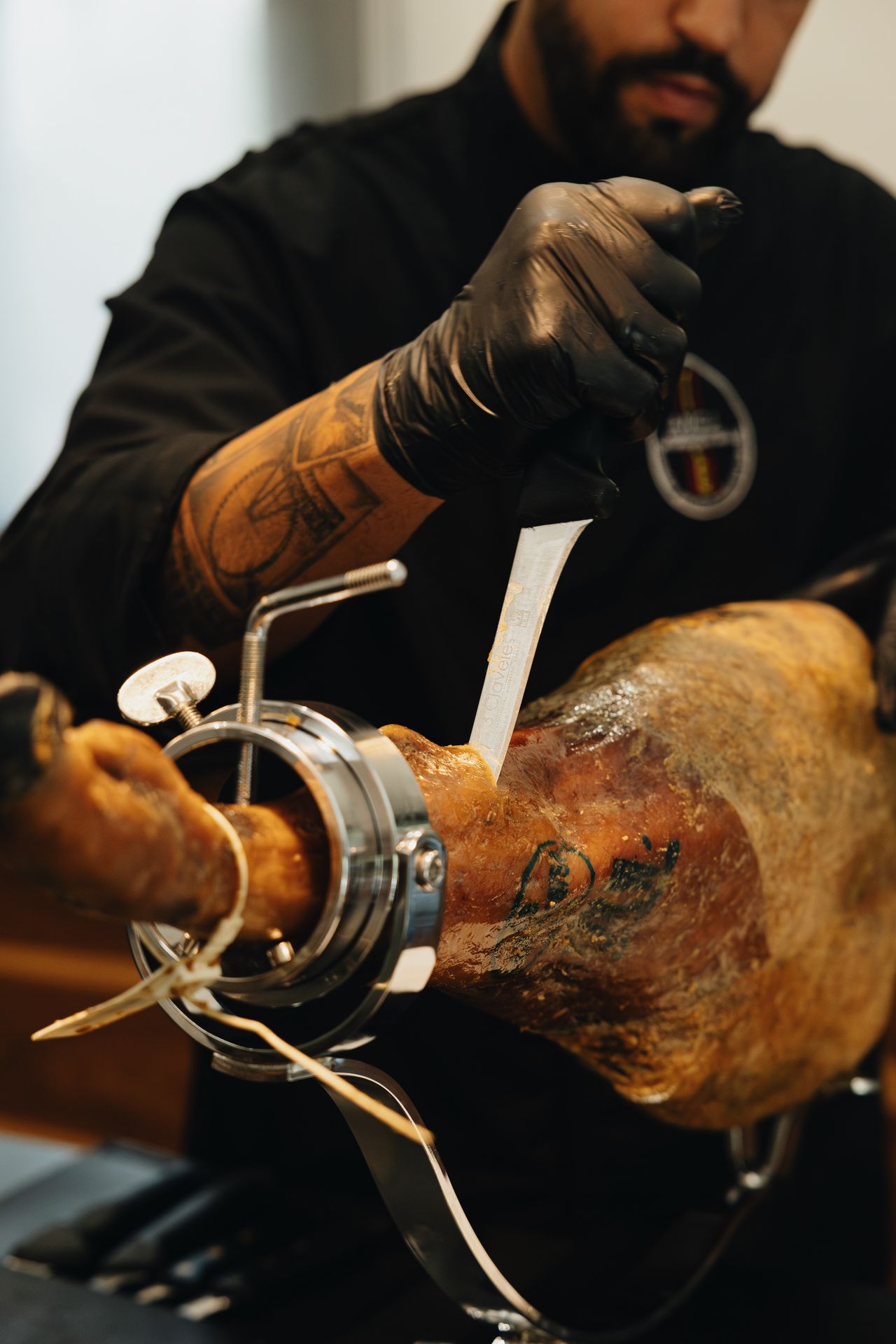 Cortador profesional realizando corte de jamón con cuchillo profesional en jamonero profesional abellan con sistema basculante patentado y sistema giratorio